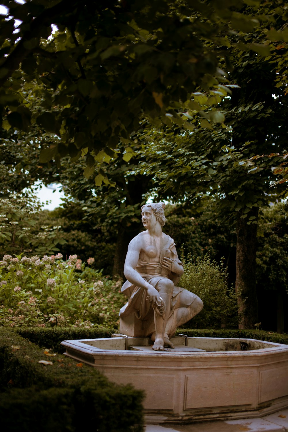 uma estátua de um homem sentado em cima de uma fonte