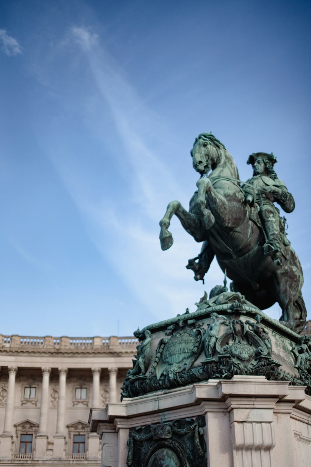 a statue of a man riding a horse in front of a building