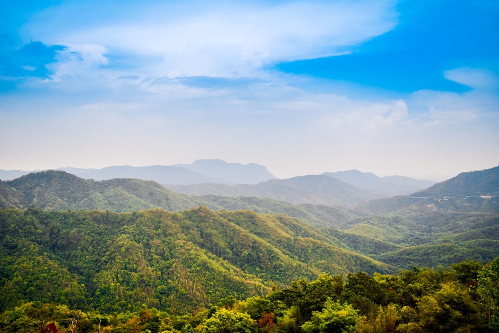 a scenic view of a mountain range with a blue sky