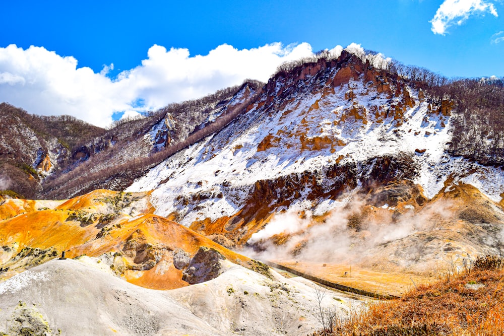 a mountain covered in snow and brown grass