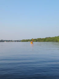 a person paddling a kayak on a calm lake