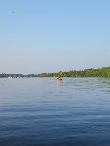a person paddling a kayak on a calm lake