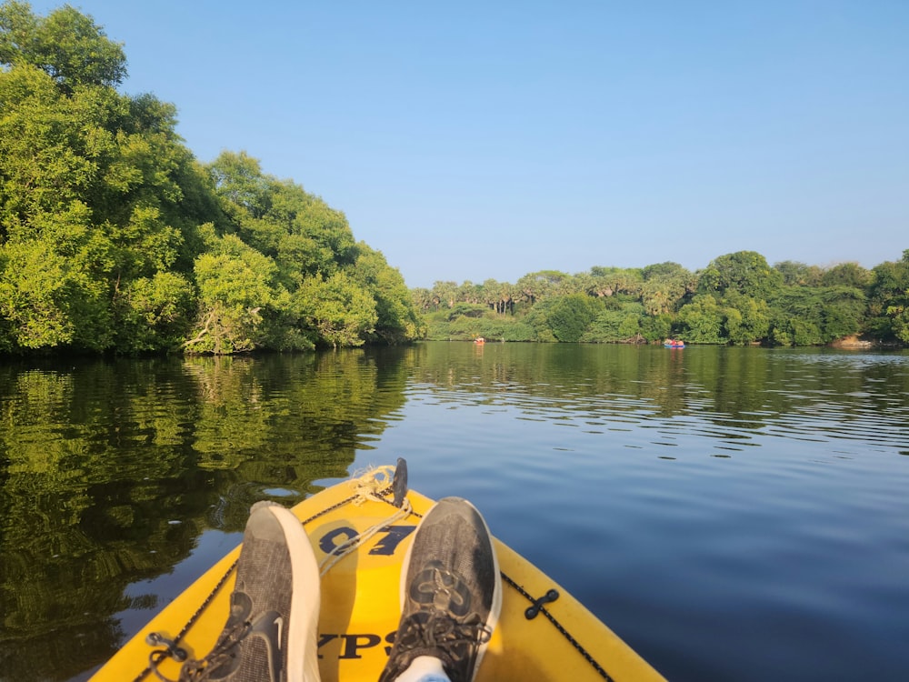 a person sitting in a yellow boat on a river