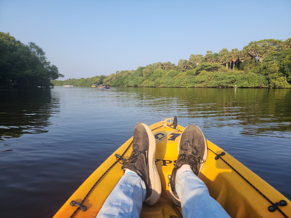 a person sitting in a yellow boat on a river