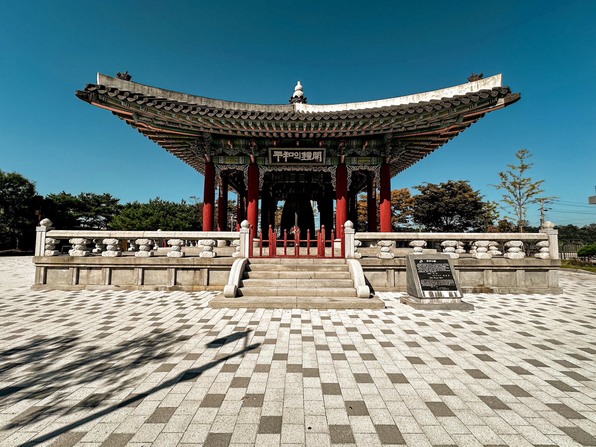 a building with a checkered floor and a tower in the background