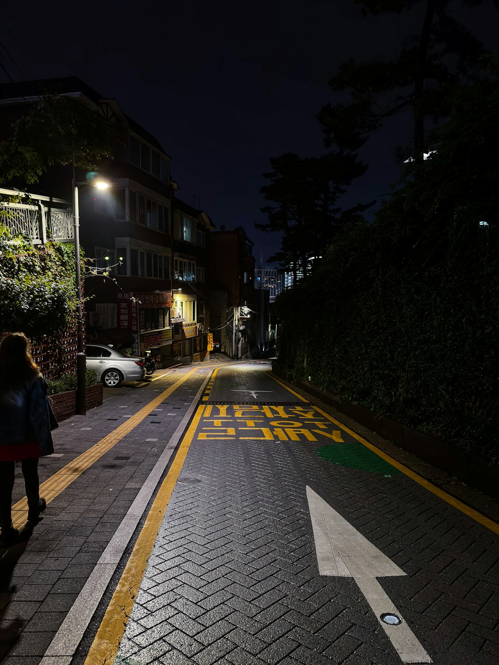 a woman walking down a street at night