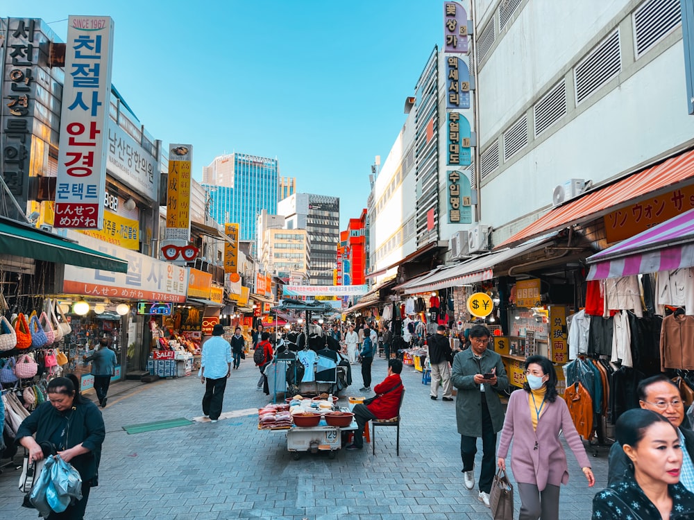 a group of people walking down a street next to tall buildings