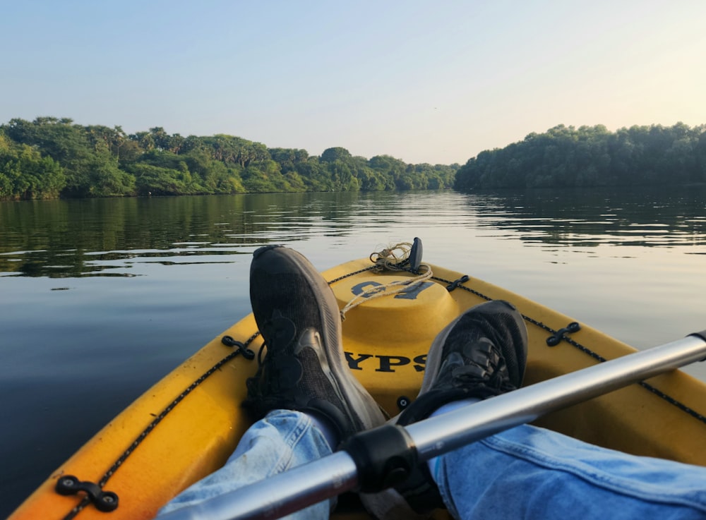 a person sitting in a yellow kayak on a river