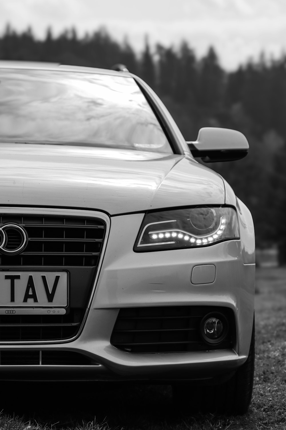 a car parked in a field with trees in the background