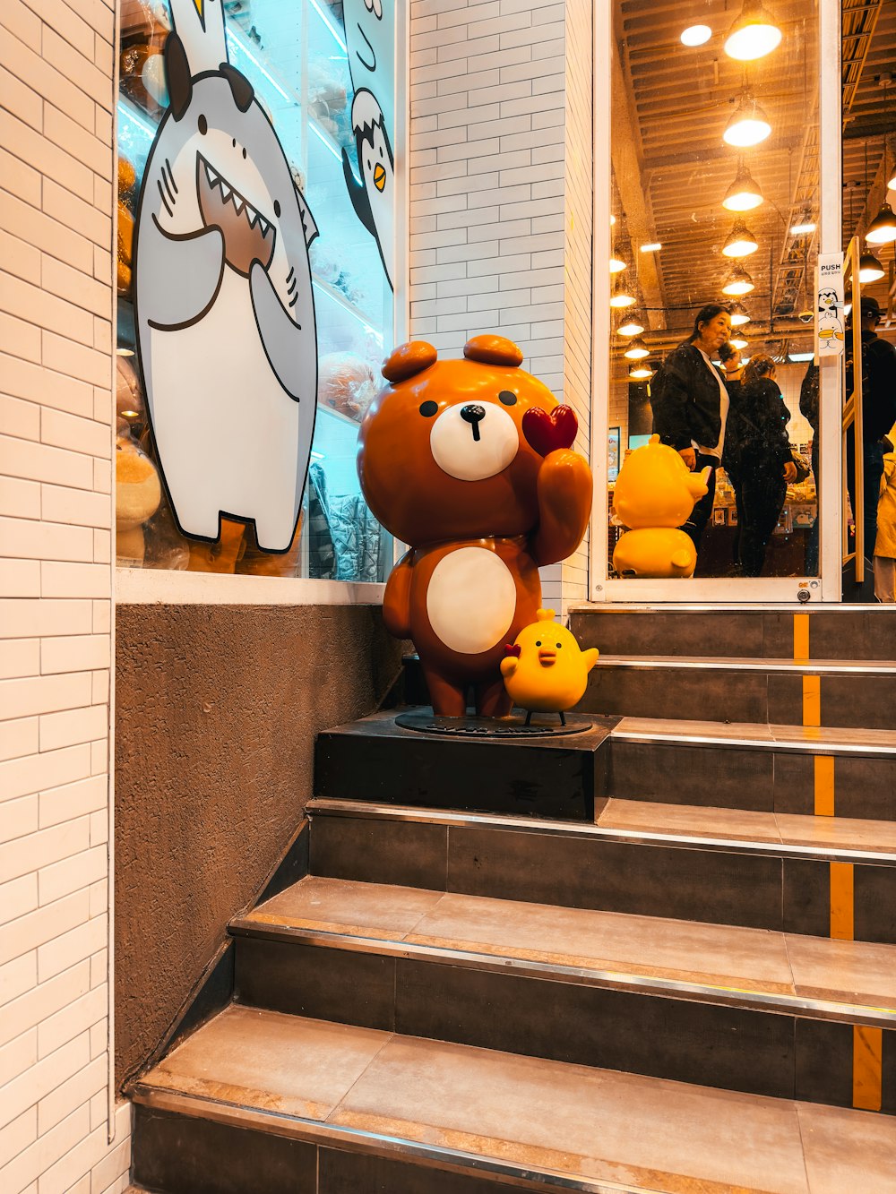 a teddy bear sitting on top of a set of stairs