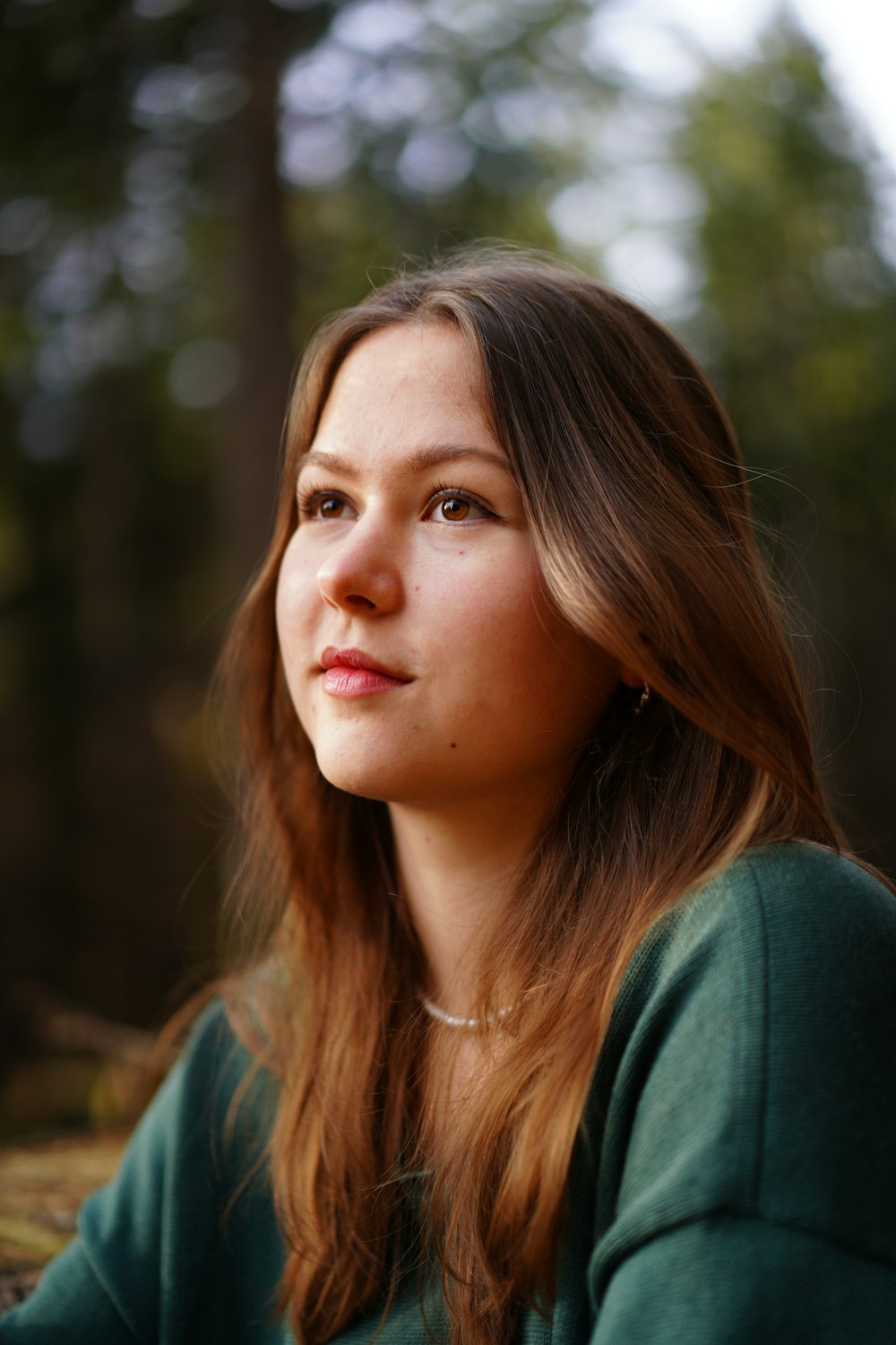 a woman with long brown hair and a green shirt