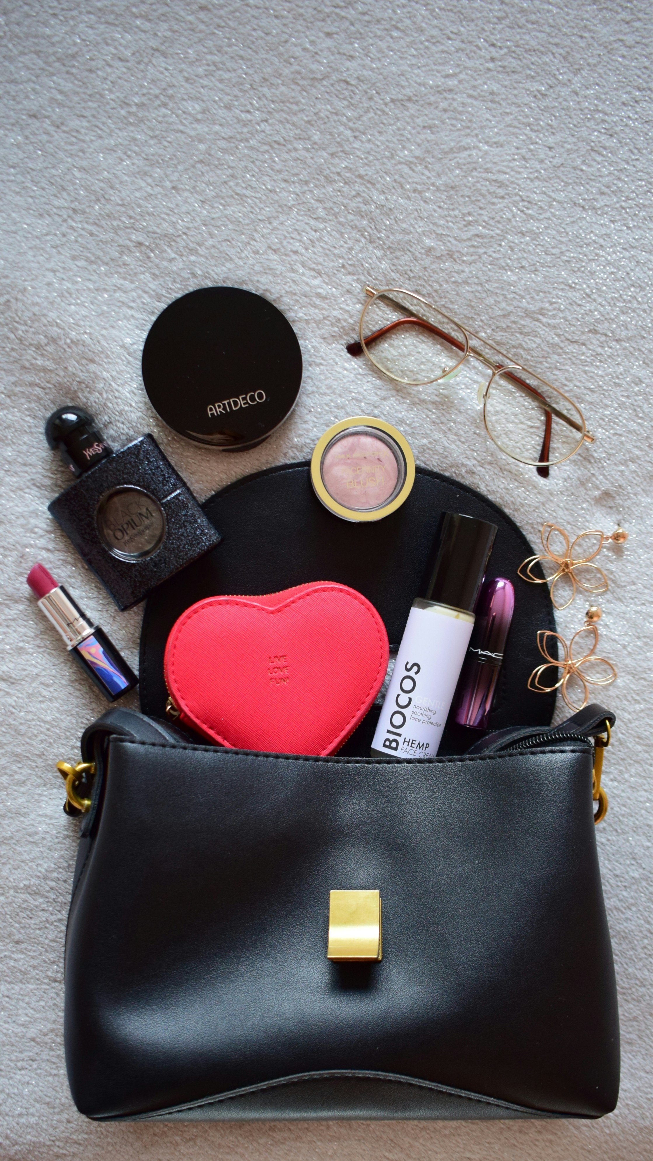 a black purse filled with makeup and other items