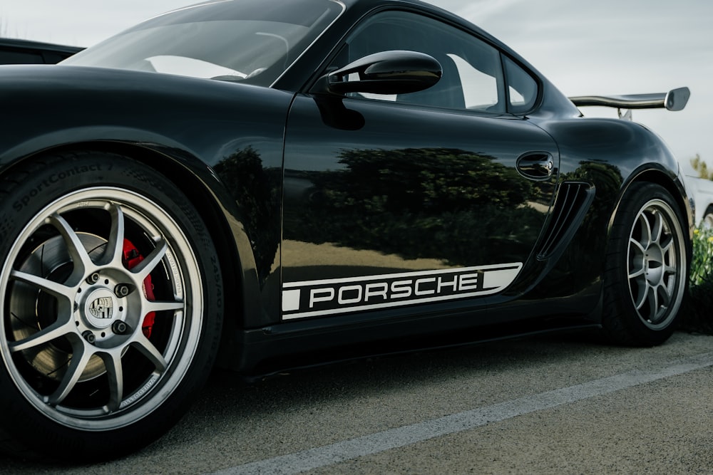 Um carro esportivo Porsche preto estacionado em um estacionamento