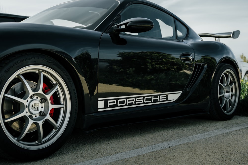 a black porsche sports car parked in a parking lot