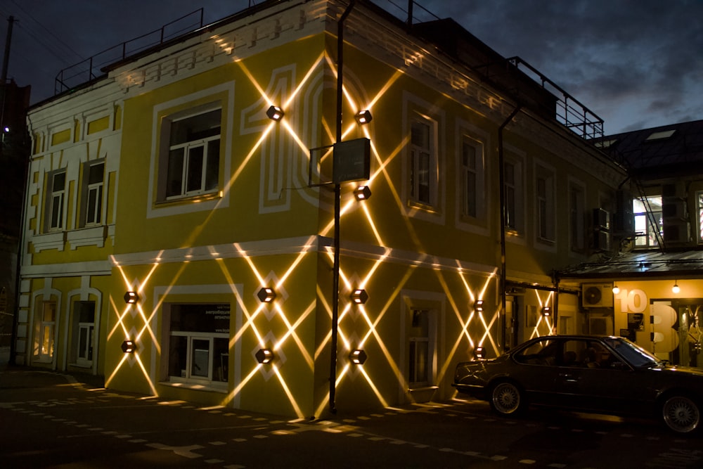 a car parked in front of a yellow building