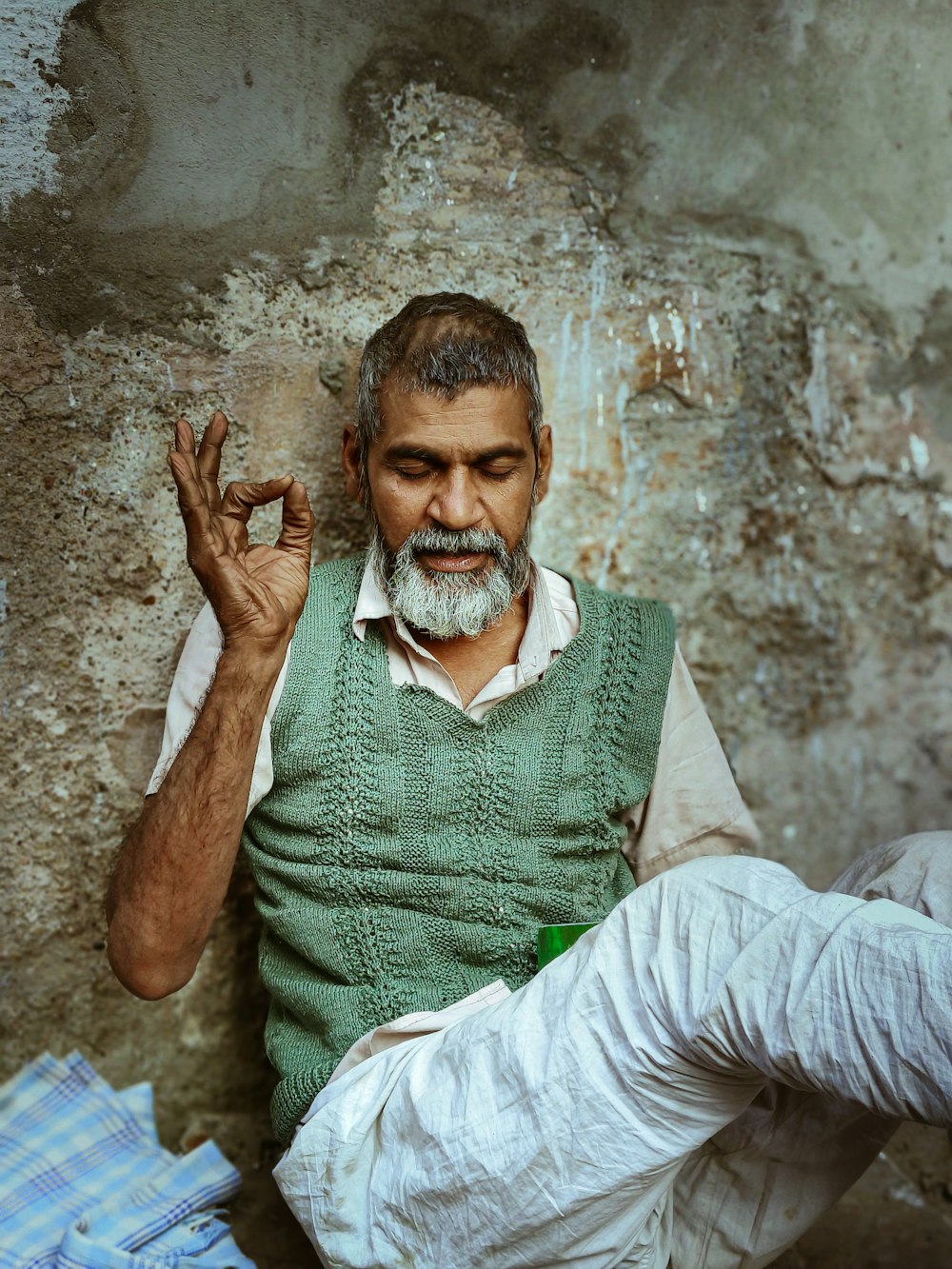 a man sitting on the ground with his hands in the air