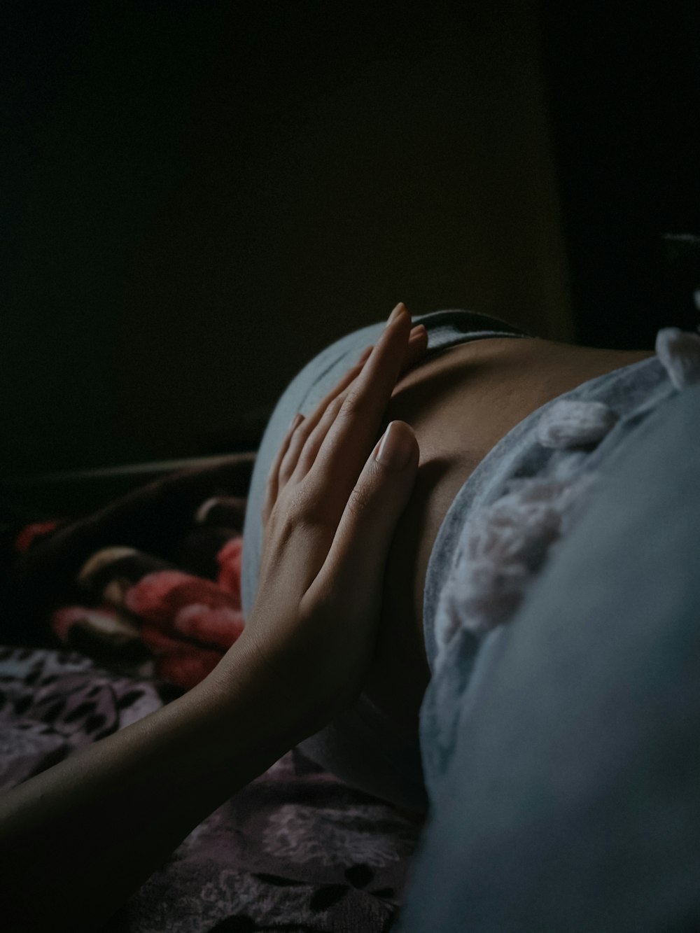 a woman laying on top of a bed with her hands on her chest