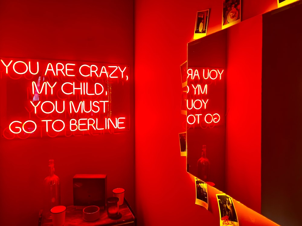 a bathroom with red walls and neon lights