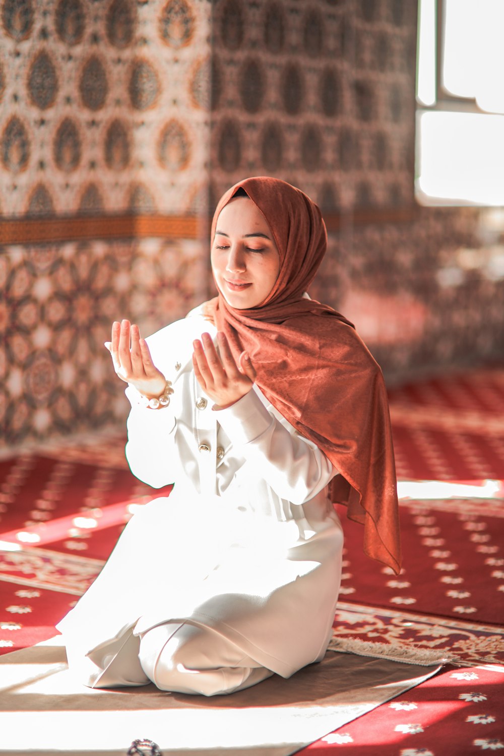 a woman in a white outfit sitting on a rug