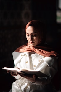 a woman in a white coat is reading a book
