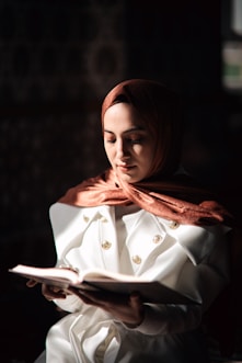 a woman in a white coat is reading a book