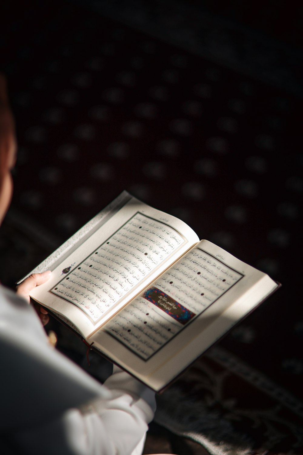 a person reading a book in the dark