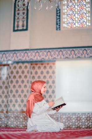 a woman sitting on the ground reading a book