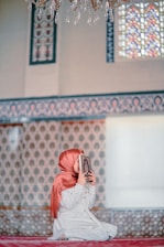 a woman sitting on the ground reading a book