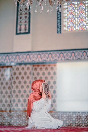 a woman sitting on the ground reading a book