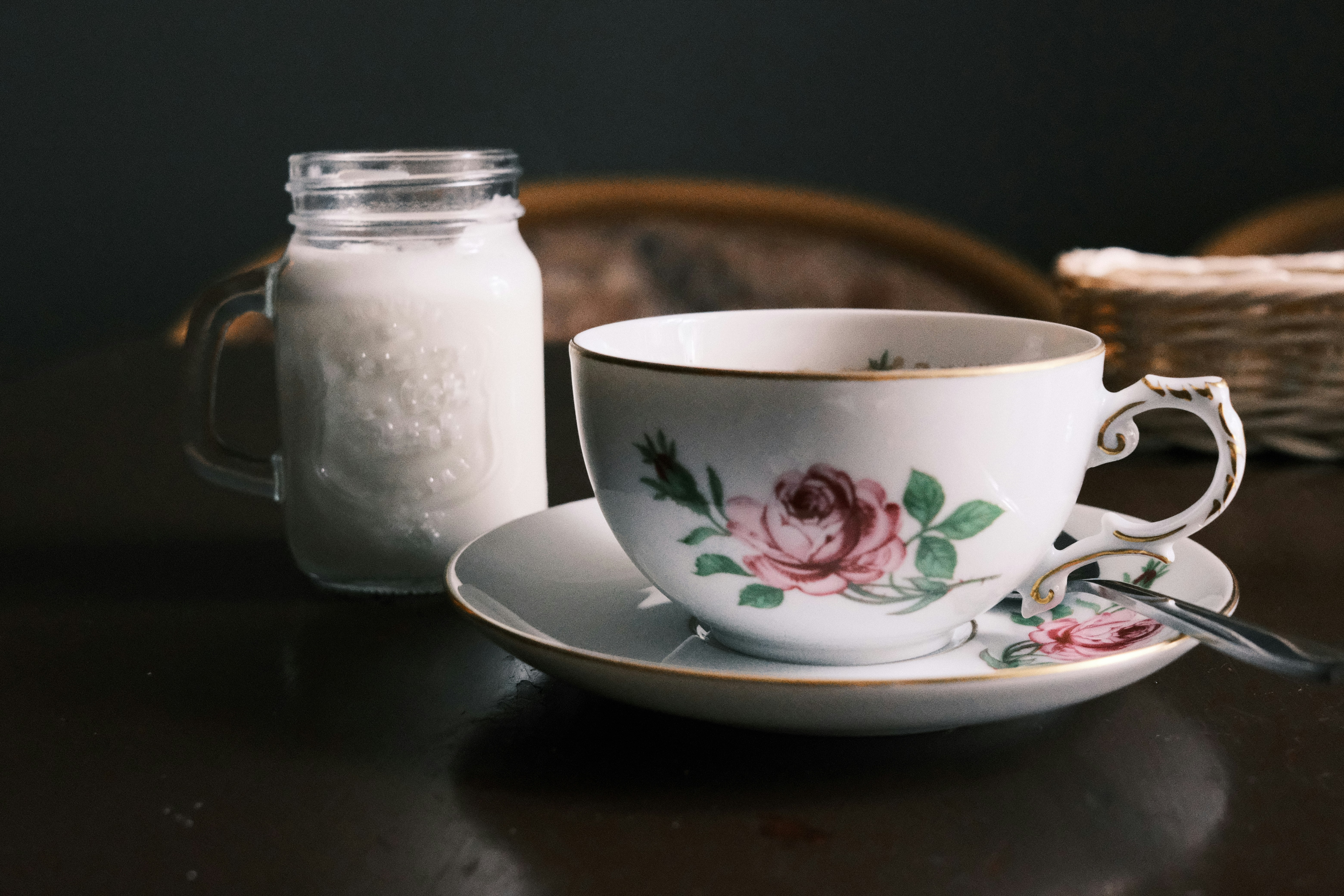 a tea cup and saucer sitting on a table next to a jar of sugar