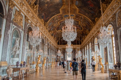 a large room with chandeliers and paintings on the walls