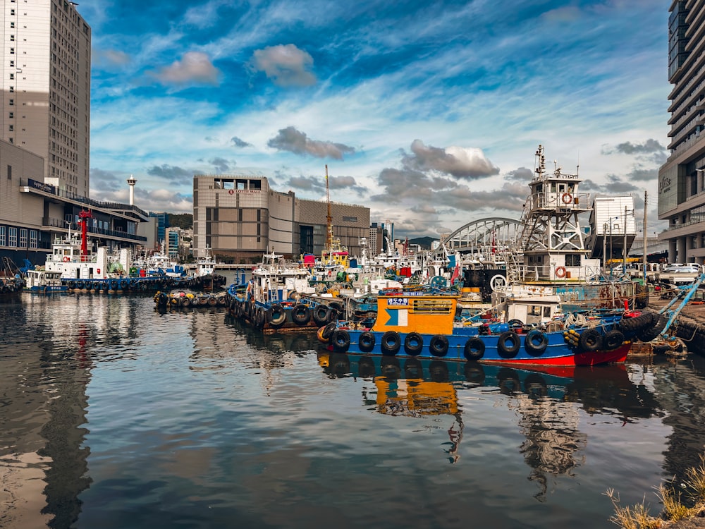 a harbor filled with lots of boats next to tall buildings