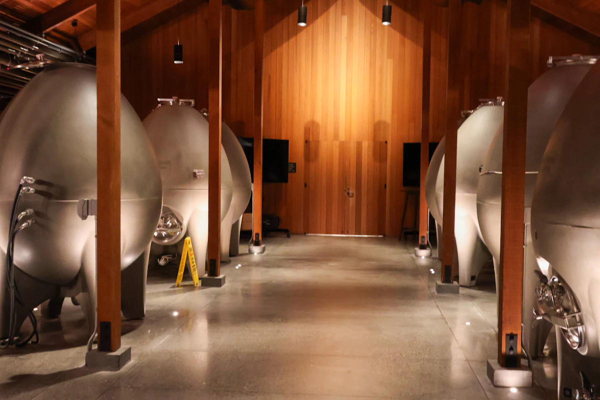 Row of stainless steel tanks inside an industrial building