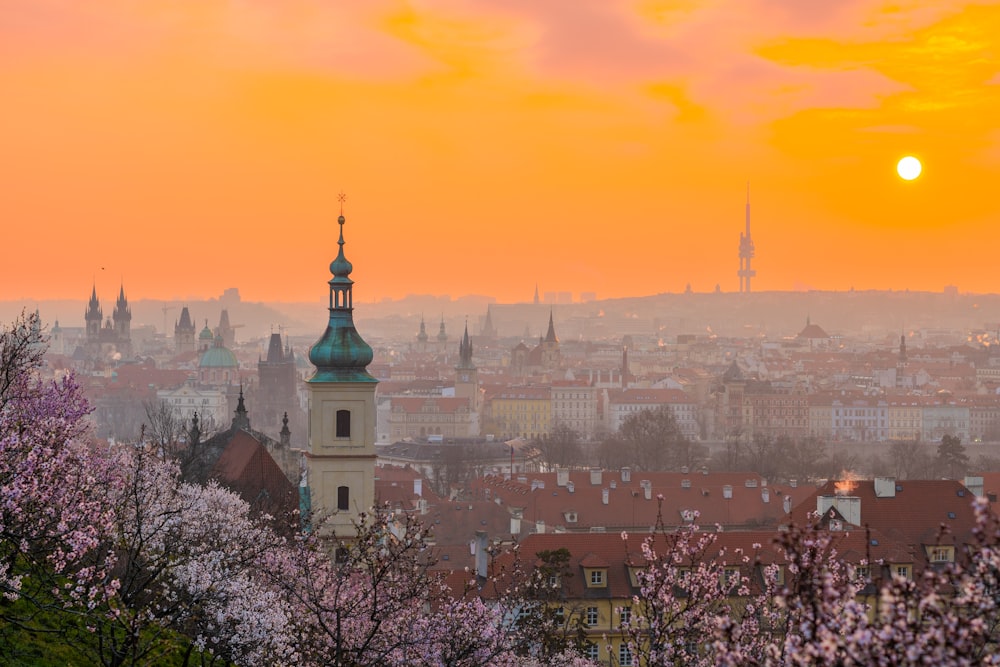 the sun is setting over the city of prague