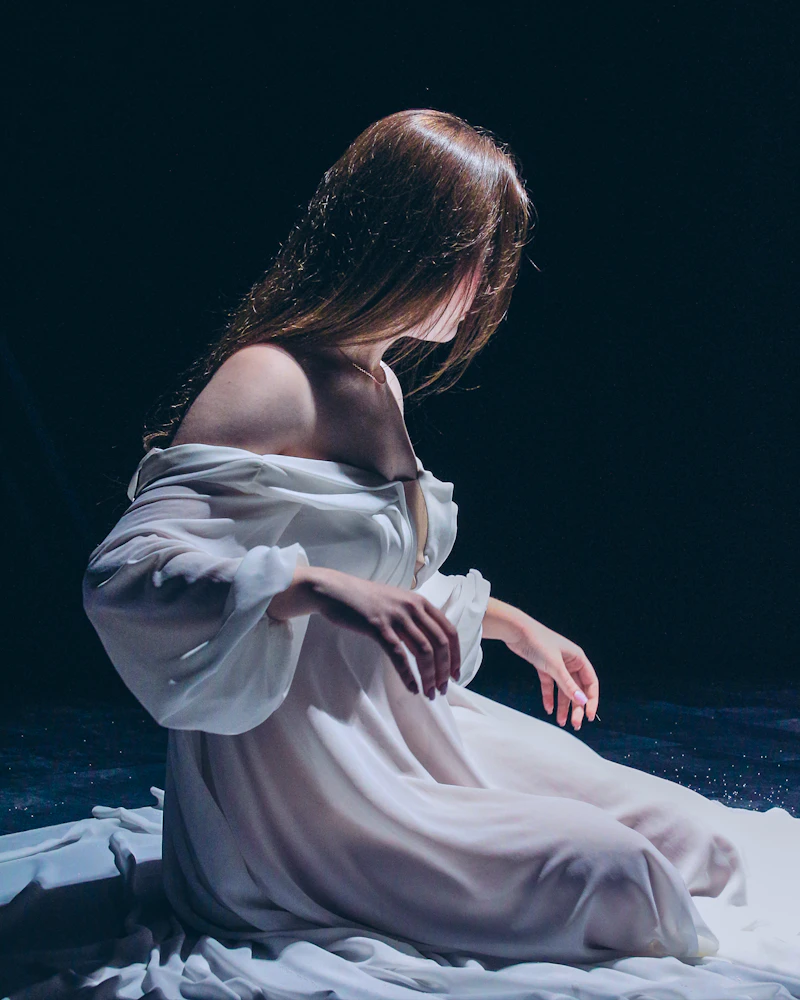 Woman seated in a white evening gown