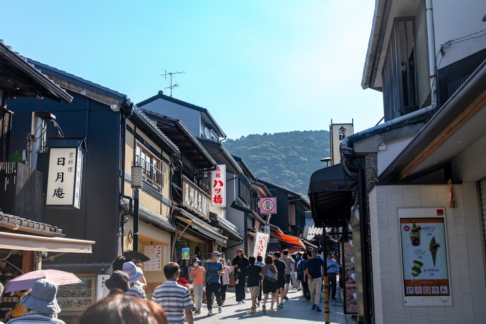 a group of people walking down a street next to tall buildings