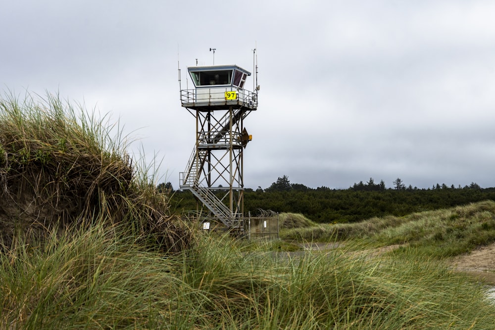 a lifeguard tower on a beach with grass in the foreground