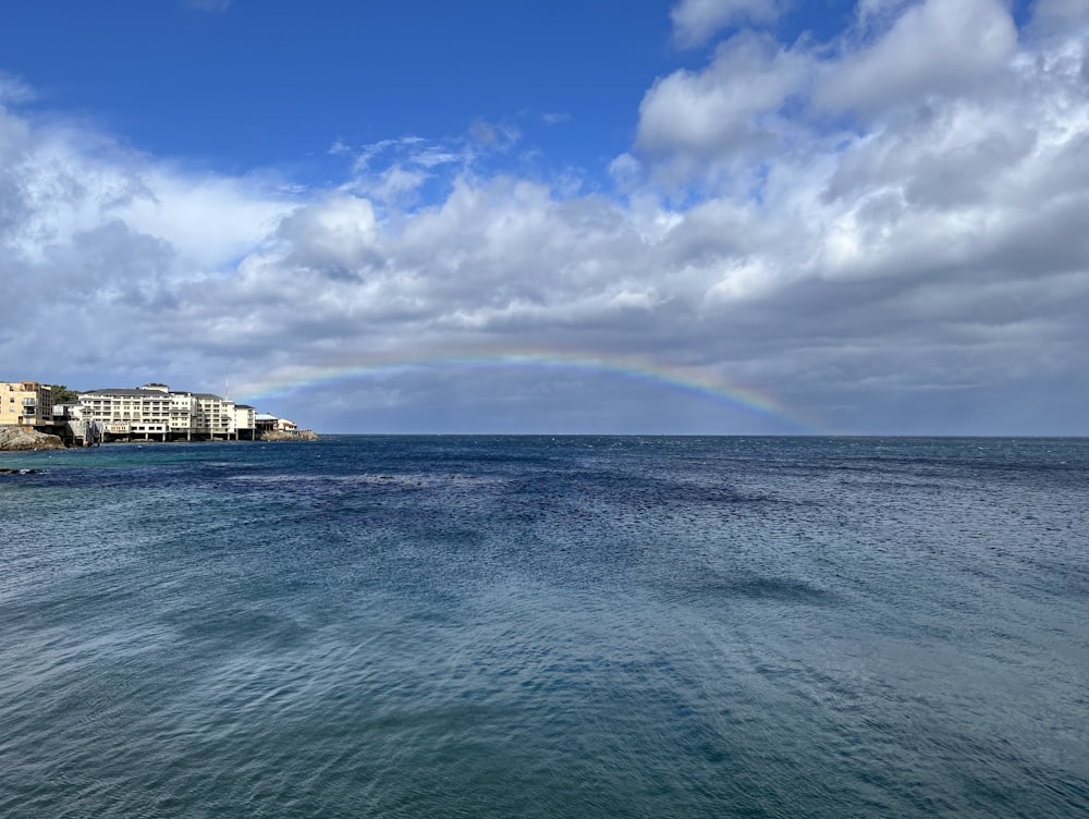 a rainbow in the sky over a body of water