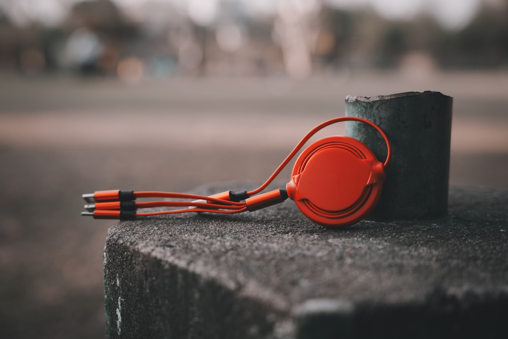 a pair of orange headphones sitting on top of a cement block
