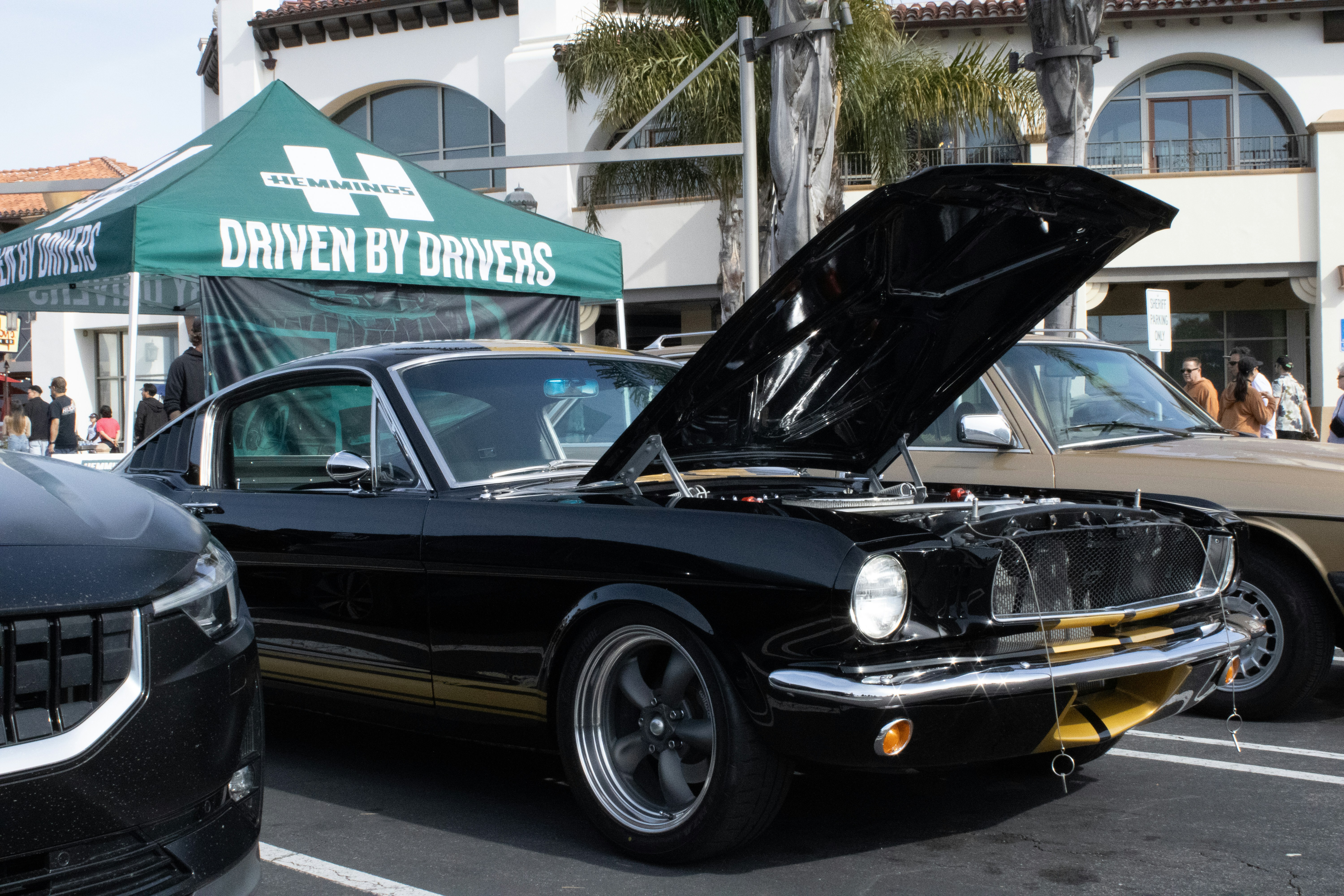 a car with its hood open parked in a parking lot