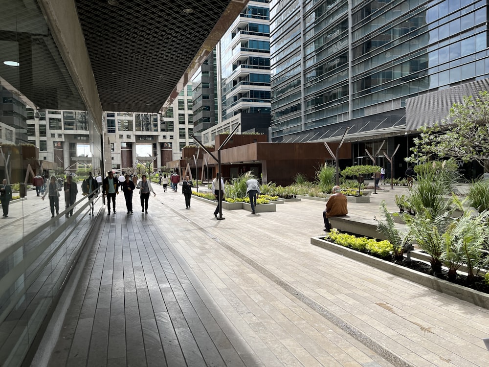 a group of people walking down a street next to tall buildings