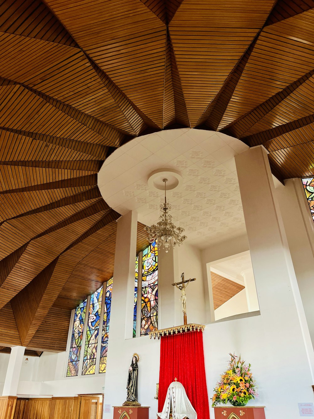 a church with stained glass windows and a wooden ceiling