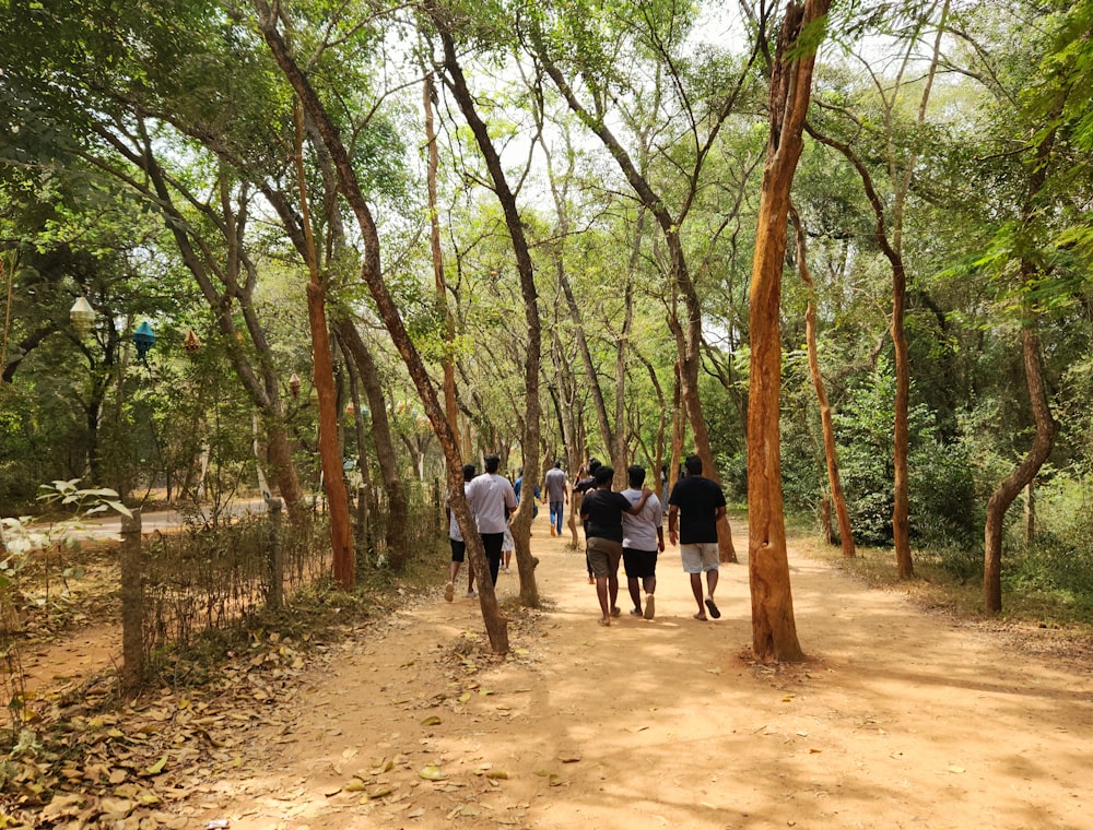 a group of people walking down a dirt road