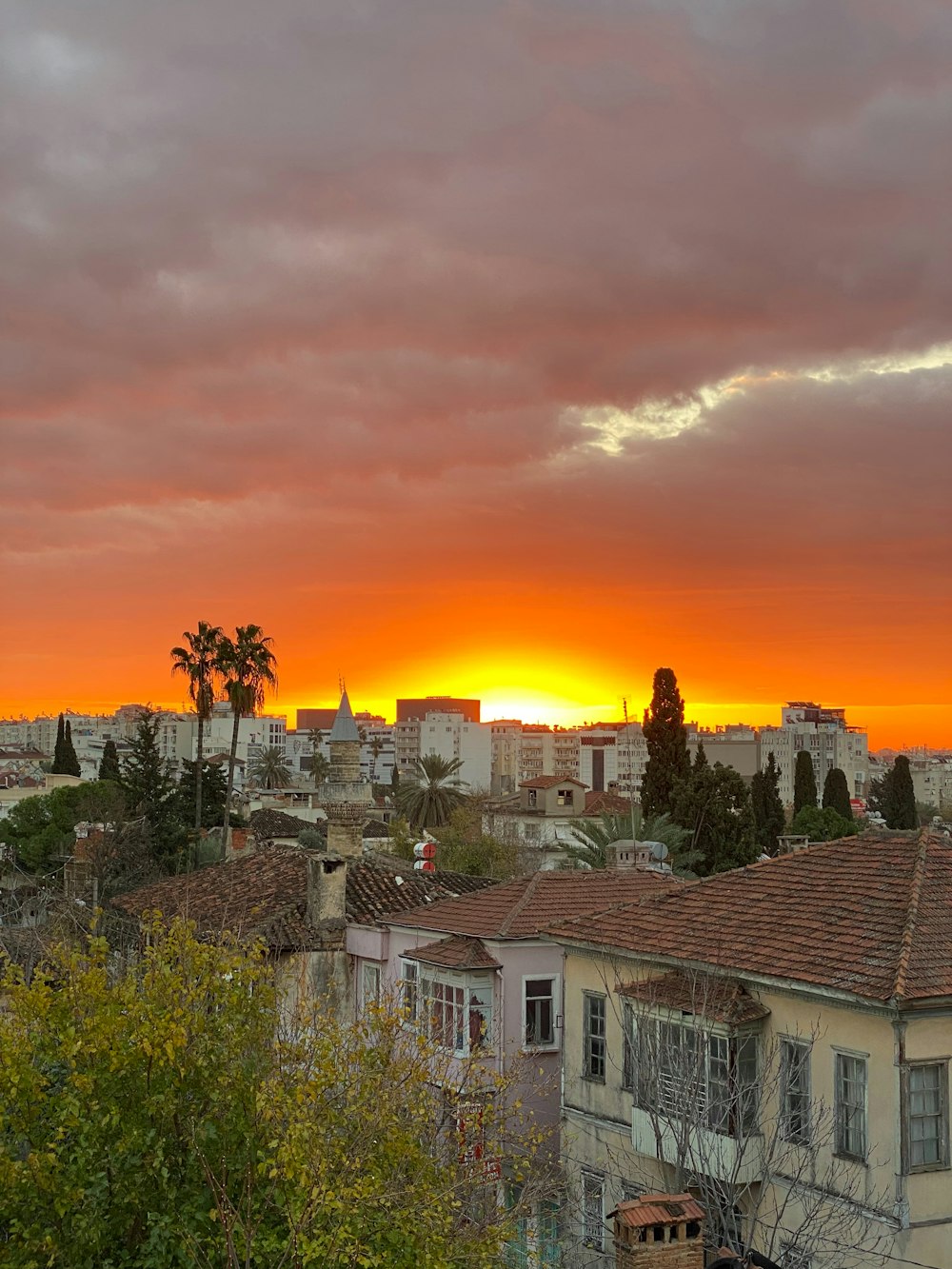 the sun is setting over a city with buildings