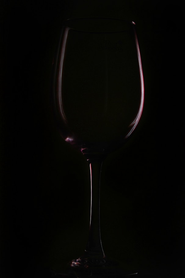 a glass of wine on a black background