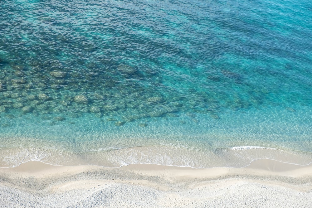 an aerial view of a beach with a boat in the water