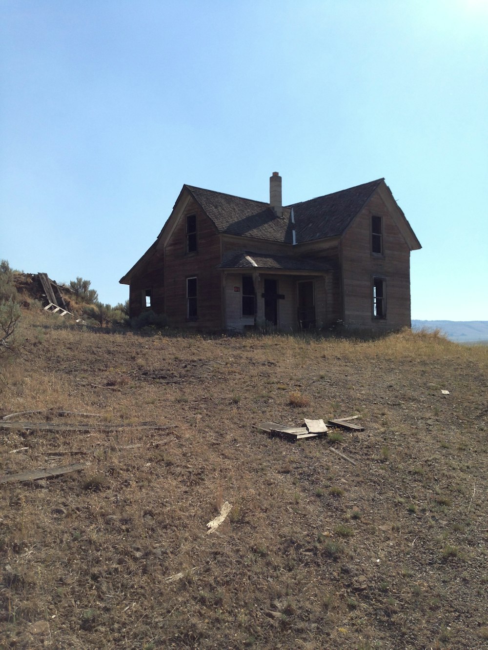 una casa en ruinas sentada en la cima de una colina