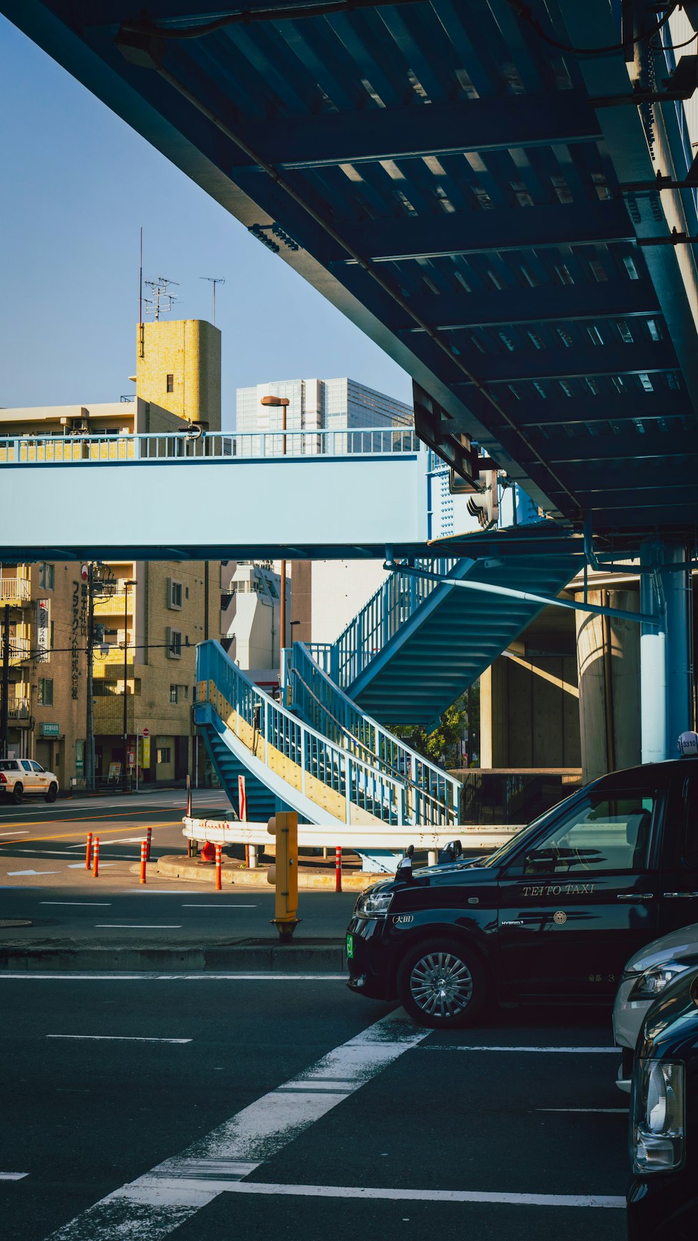 a car driving under a bridge next to a tall building