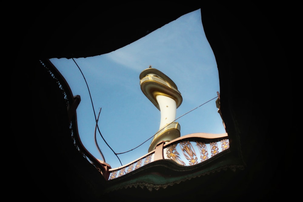 a view of a tower through a hole in the roof of a building