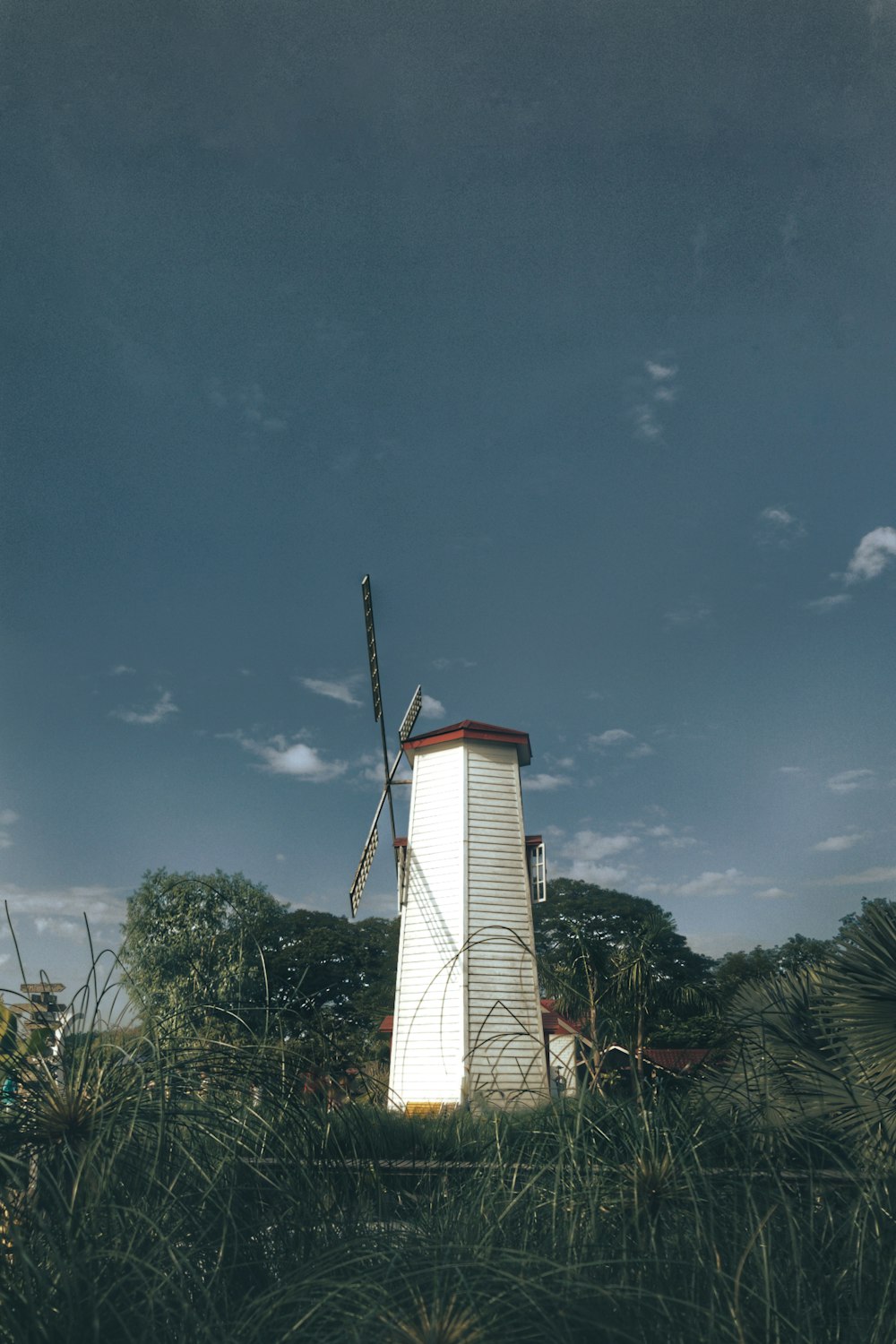 a windmill in the middle of a grassy field